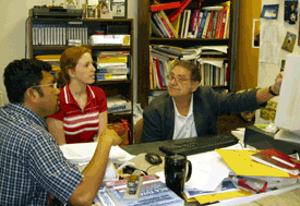 Photo of Dr. Tiffany Barnes, center, discussing a research project with Dr. Donald Bitzer, Distinguished University Research Professor, right, and colleague Lalit Ponnala.
