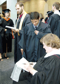 Photo of Joyce Hatch checking in graduates prior to the diploma ceremony.